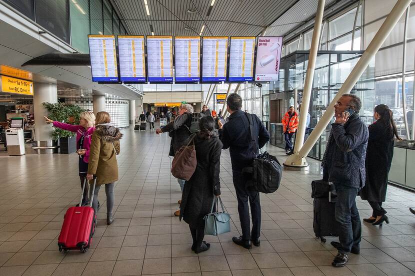 Reizigers in de vertrekhal van Schiphol